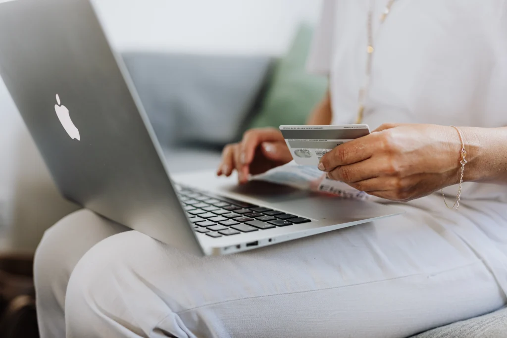 Woman making an online purchase with a credit card through a Mac laptop.